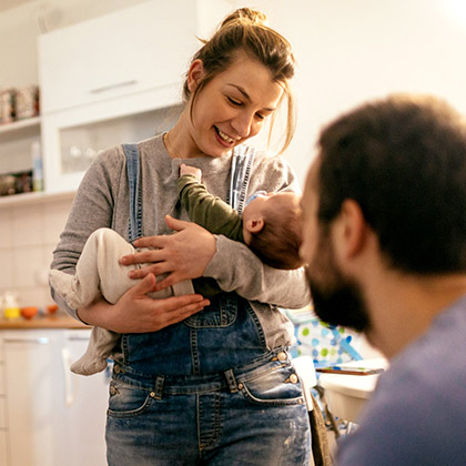 Young parents and child in kitchen.